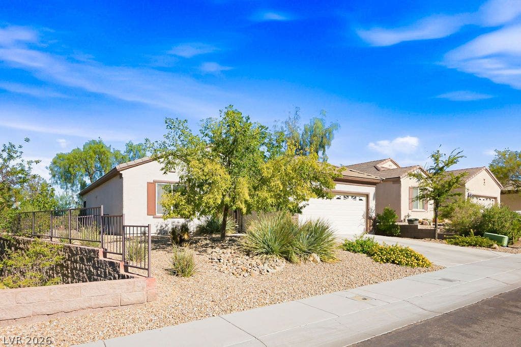 2510 Hamonah Drive, Henderson, NV 89044 Desert landscaping and a paved driveway complement this single-story stucco home.