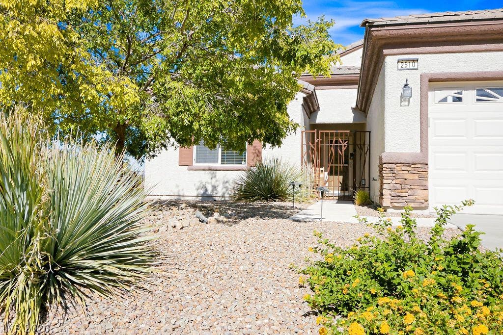 2510 Hamonah Drive, Henderson, NV 89044 Desert landscaping and stone accents frame the welcoming entrance of this classic stucco home.