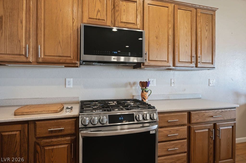 2510 Hamonah Drive, Henderson, NV 89044 Classic wooden cabinetry frames a modern stainless steel gas range and built-in microwave.
