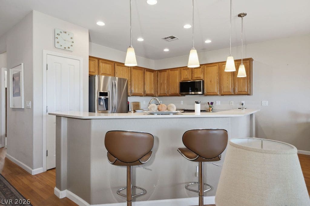 2510 Hamonah Drive, Henderson, NV 89044 Warm wood cabinetry and solid stone countertops anchor this inviting kitchen space.