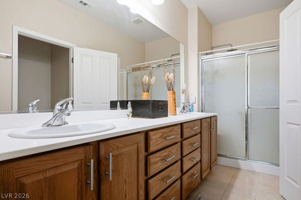 2510 Hamonah Drive, Henderson, NV 89044 An expansive double vanity and glass-enclosed shower highlight this functional bathroom space.