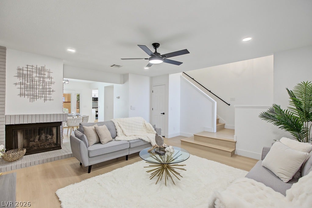 2371 Pickwick Drive, Henderson, NV 89014 A cozy brick fireplace anchors this open living space featuring light wood flooring.