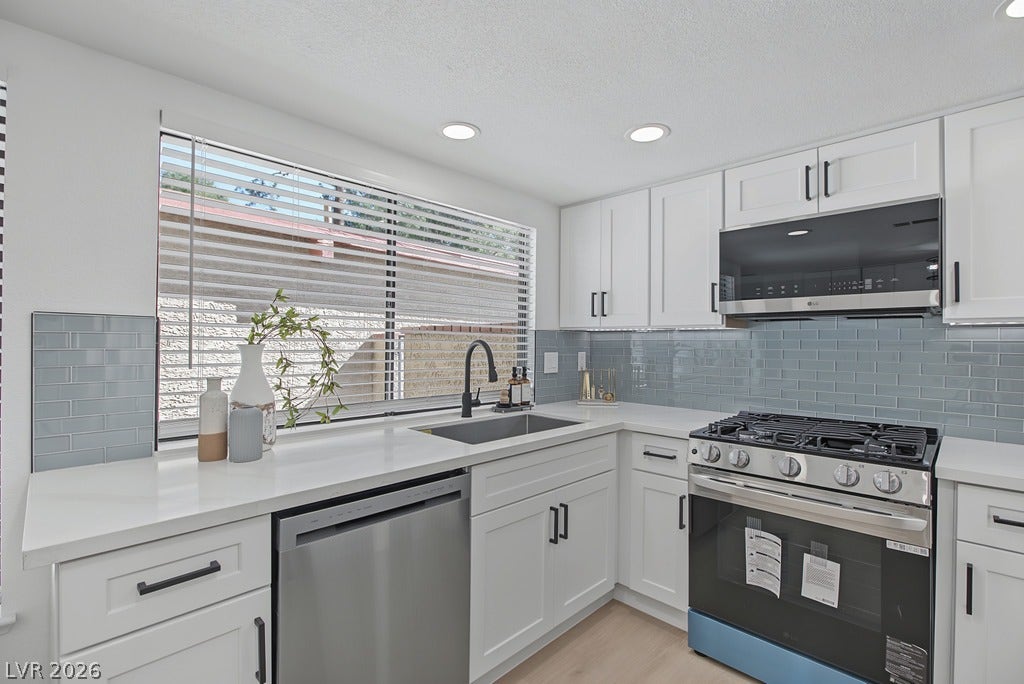 2371 Pickwick Drive, Henderson, NV 89014 Gleaming stone countertops and a modern tiled backsplash define this bright, updated kitchen space.