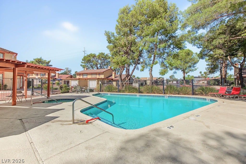 2371 Pickwick Drive, Henderson, NV 89014 Mature trees frame a sparkling community pool and adjacent spa surrounded by concrete decking.