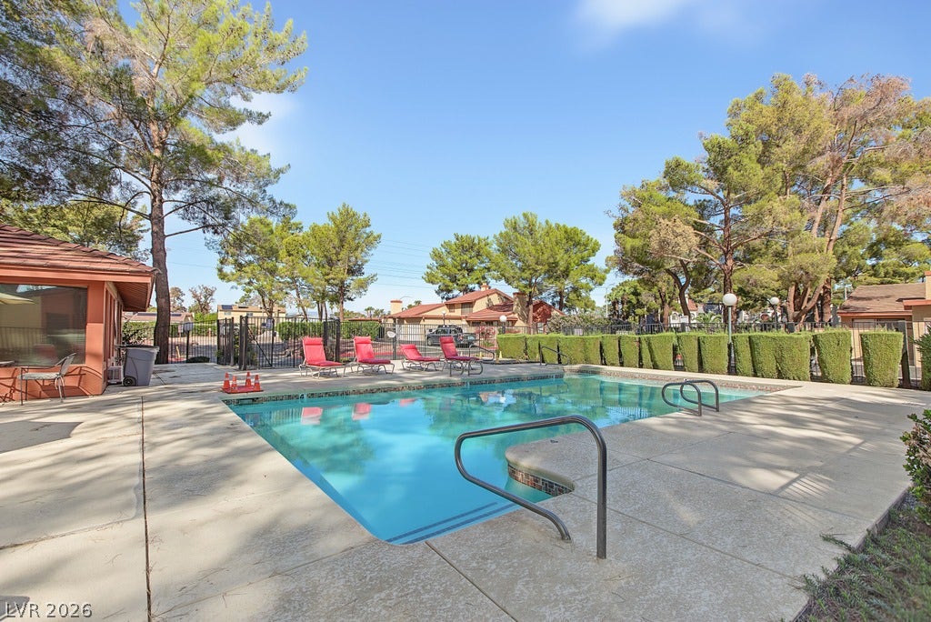 2371 Pickwick Drive, Henderson, NV 89014 Mature trees surround a sparkling blue swimming pool bordered by a concrete sun deck.
