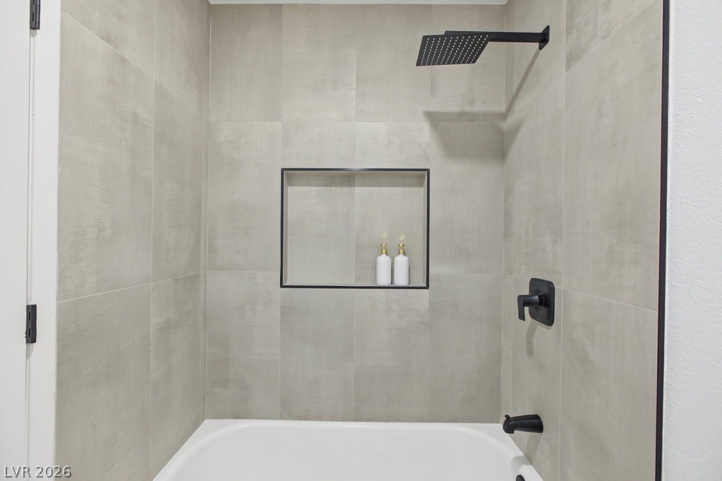 2371 Pickwick Drive, Henderson, NV 89014 Sleek matte black hardware pairs with modern large-format tile surrounding the bathtub shower combination.