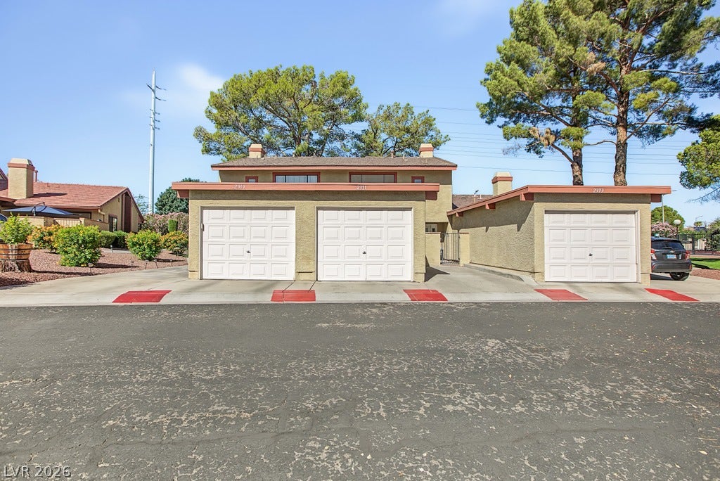 2371 Pickwick Drive, Henderson, NV 89014 Low-maintenance stucco exteriors feature three attached garages set against mature pine trees.