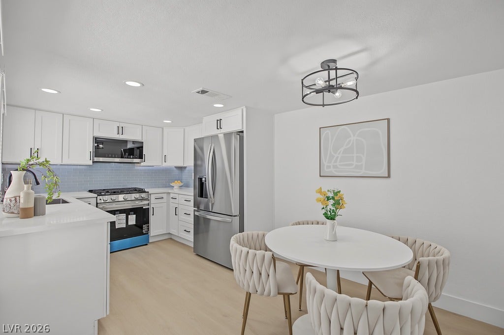 2371 Pickwick Drive, Henderson, NV 89014 Gleaming wood floors anchor this updated kitchen featuring modern white cabinetry and stone counters.