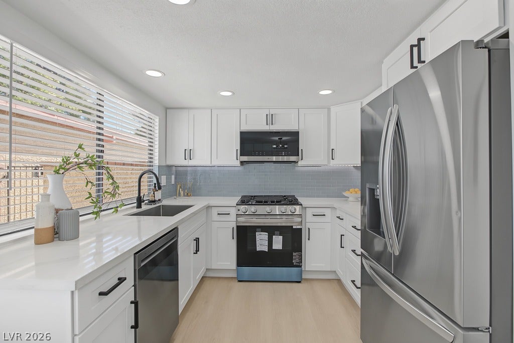 2371 Pickwick Drive, Henderson, NV 89014 Gleaming stone countertops and modern cabinetry frame this pristine, well-lit kitchen space.
