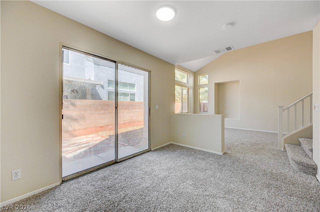 2706 Guidance Court, North Las Vegas, NV 89031 Sliding glass doors open to the outdoors, complementing carpeted floors and vaulted ceilings.