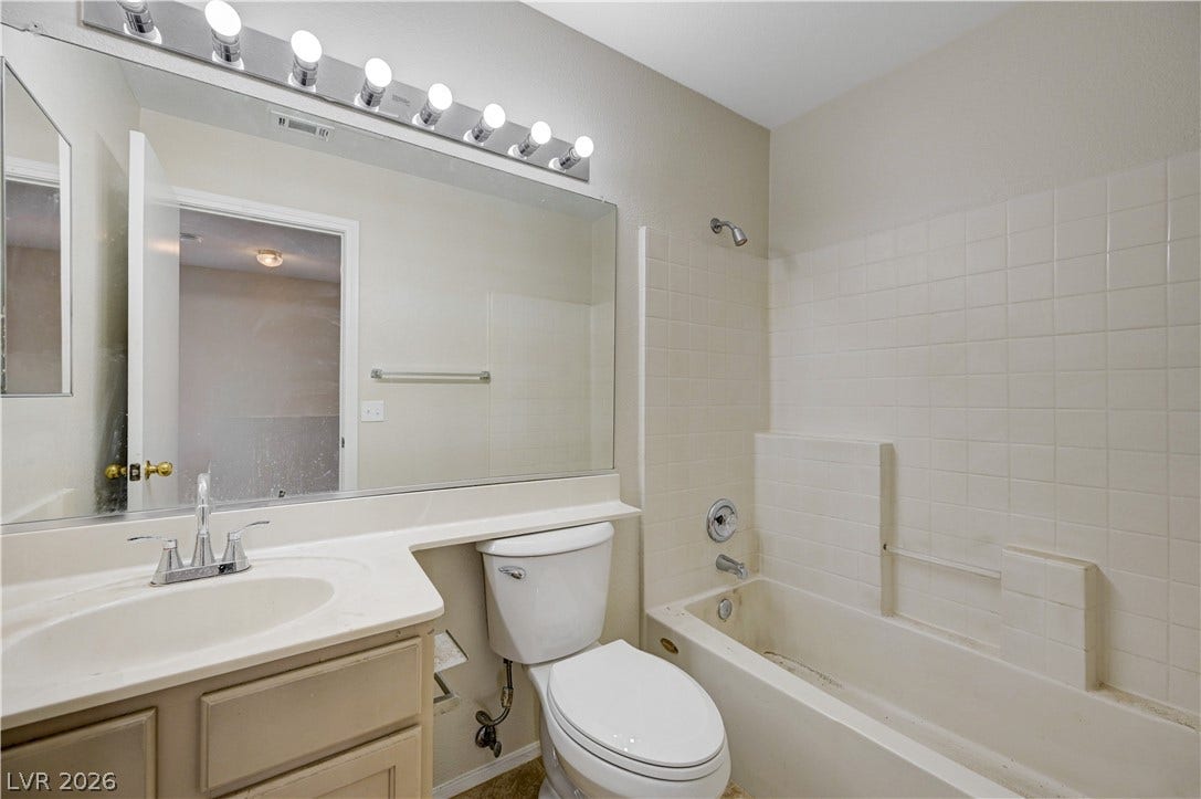 2706 Guidance Court, North Las Vegas, NV 89031 Tiled walls and a broad vanity mirror define this functional bathroom space.