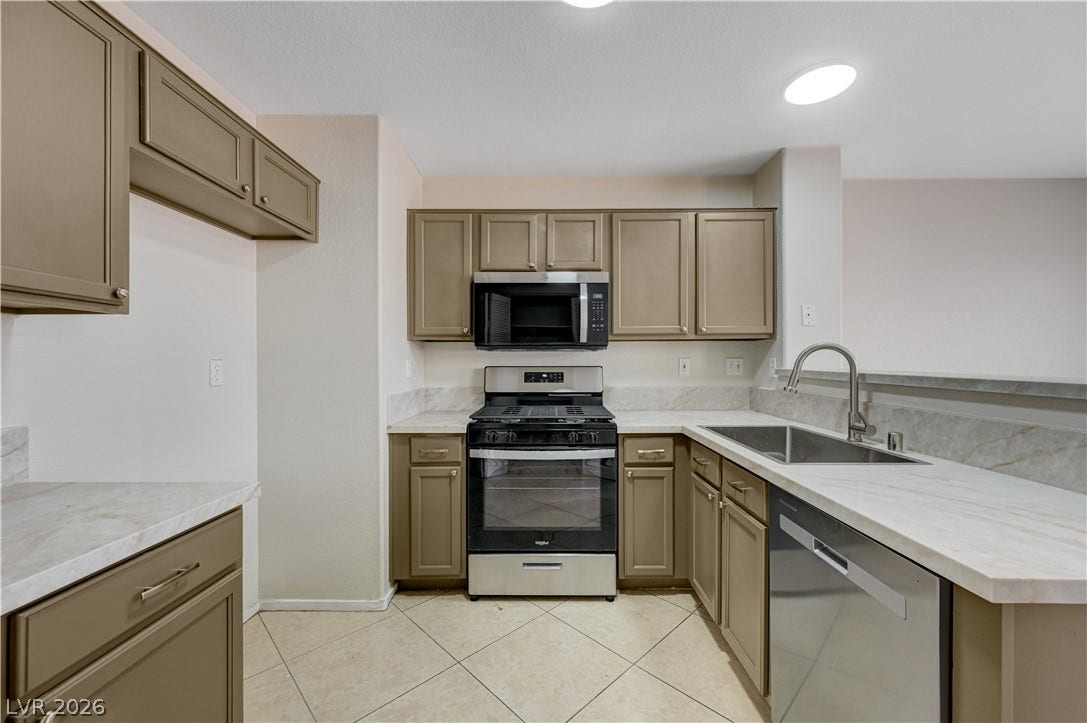 2706 Guidance Court, North Las Vegas, NV 89031 Ample cabinetry and stone countertops frame this functional kitchen workspace.