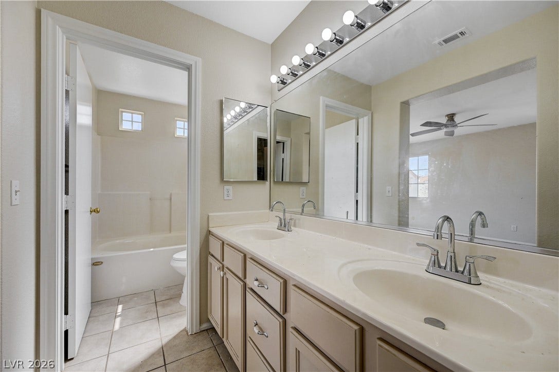 2706 Guidance Court, North Las Vegas, NV 89031 A spacious double vanity matches the neutral tile flooring and tiled bathing area.