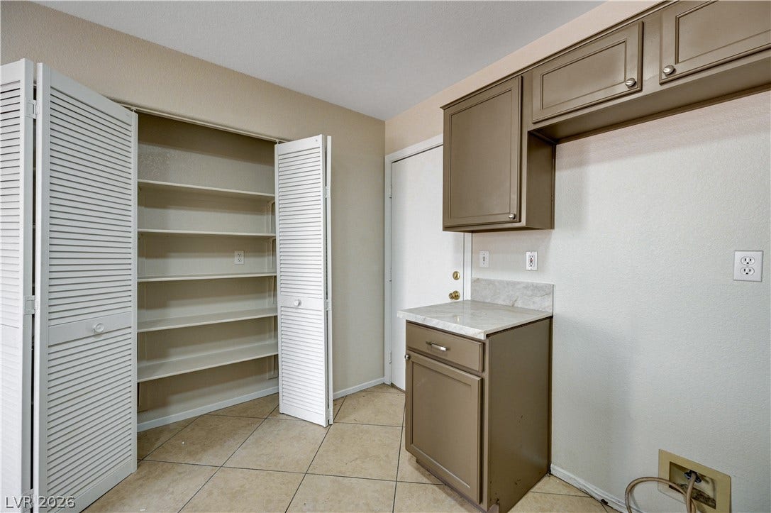 2706 Guidance Court, North Las Vegas, NV 89031 Functional utility space with built-in cabinetry, durable tile flooring, and a spacious pantry closet.