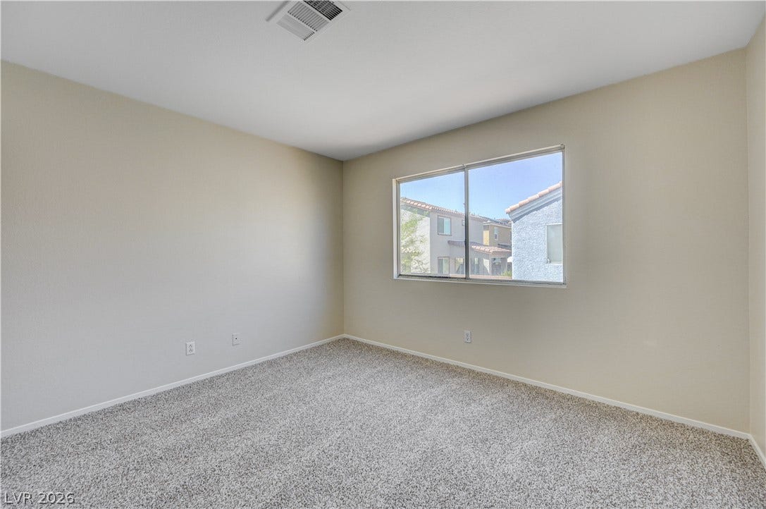2706 Guidance Court, North Las Vegas, NV 89031 Natural light streams through a large window over plush neutral carpeting in this bedroom.