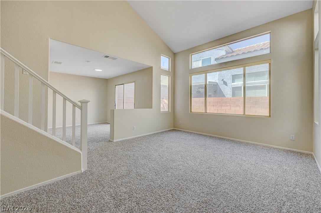 2706 Guidance Court, North Las Vegas, NV 89031 Soaring vaulted ceilings and large windows highlight this spacious living area with plush carpeting.