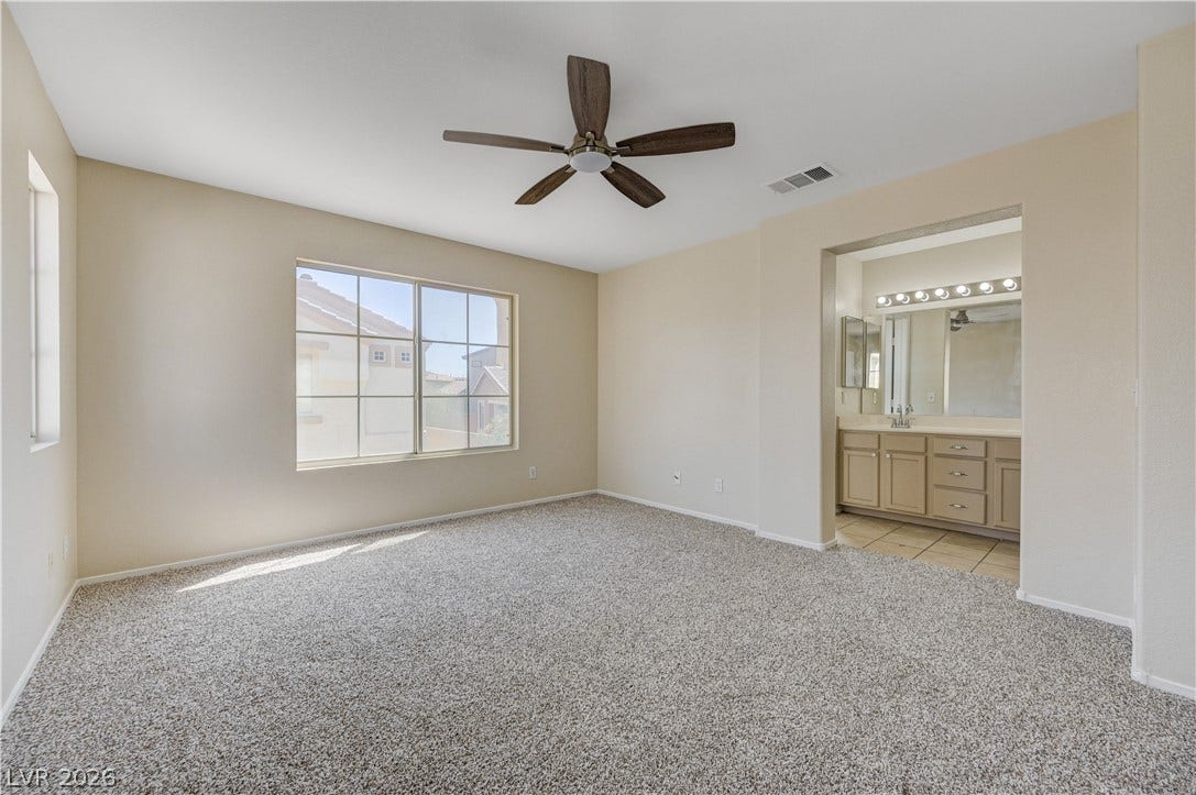 2706 Guidance Court, North Las Vegas, NV 89031 Plush carpeting and wide windows define this light-filled primary suite with adjoining vanity access.