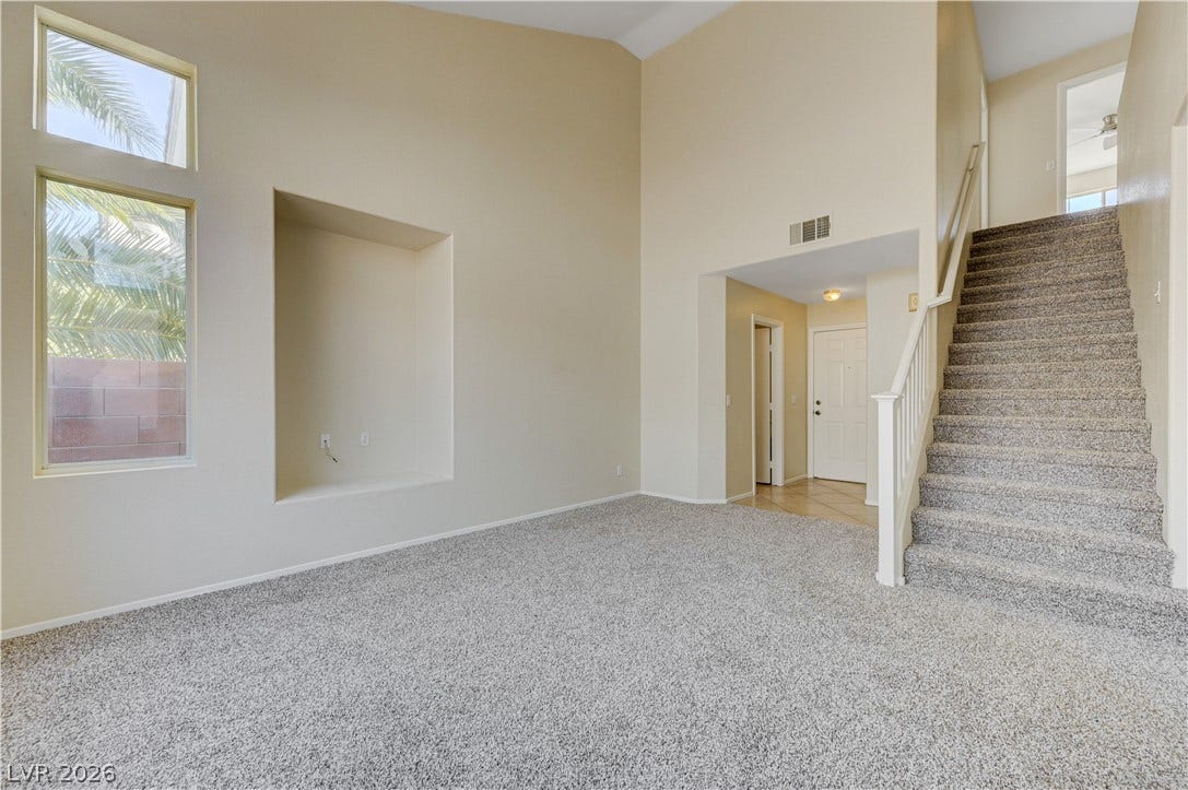 2706 Guidance Court, North Las Vegas, NV 89031 High vaulted ceilings and tall windows bring an open feel to this carpeted living area.
