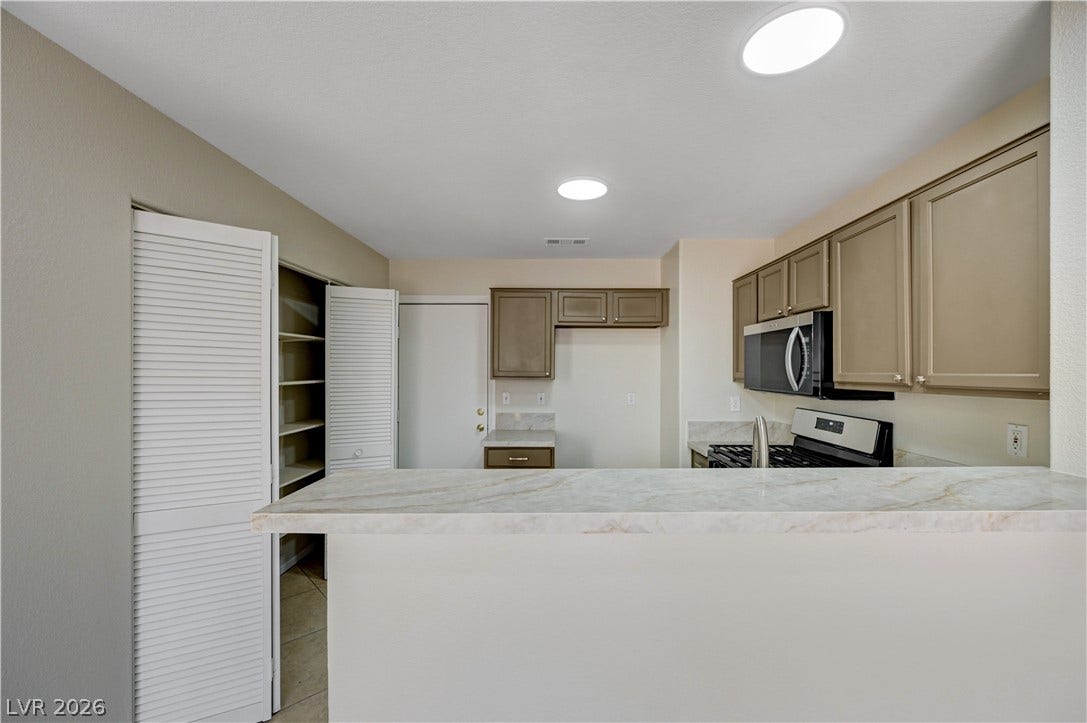 2706 Guidance Court, North Las Vegas, NV 89031 Natural stone counters and built-in storage define this functional kitchen space.
