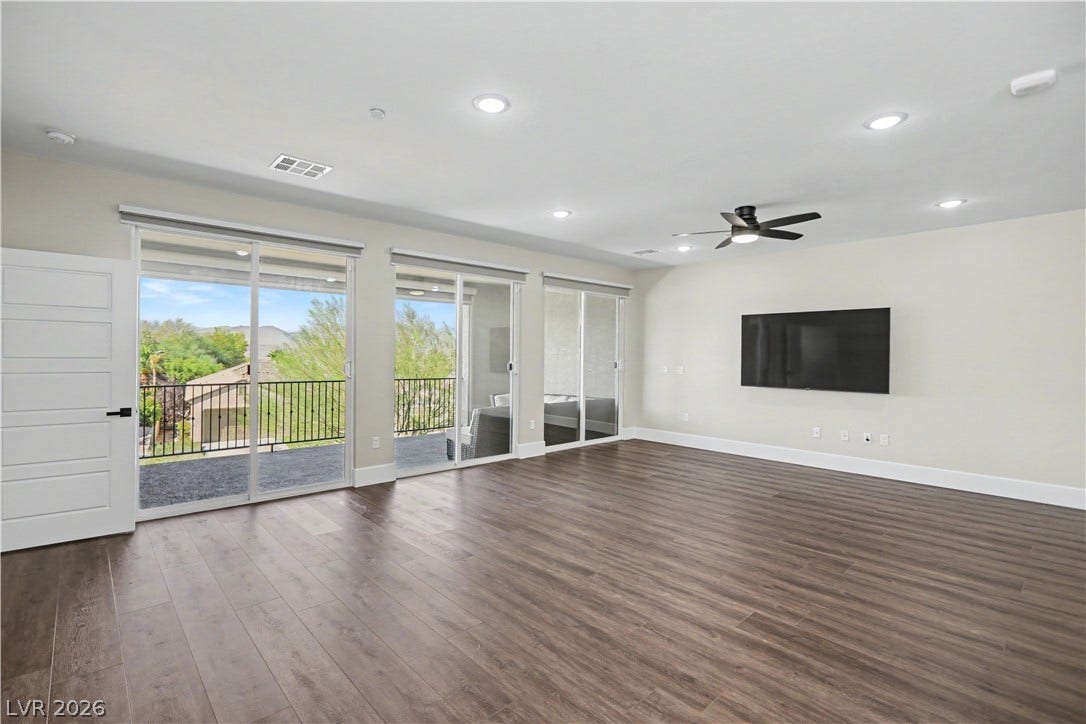 2555 Hampton Road, #11210, Henderson, NV 89052 Wide open and full of light, this living area offers seamless indoor-outdoor living with three sliders leading to the balcony.