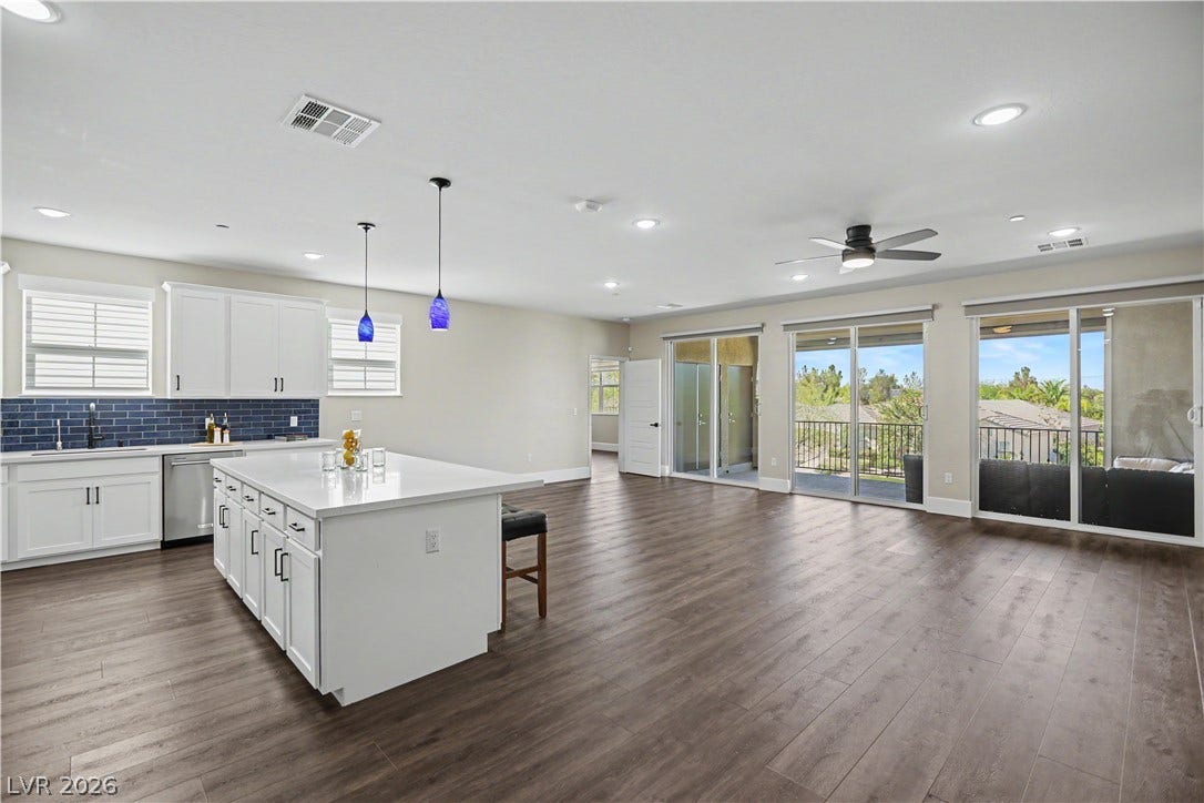 2555 Hampton Road, #11210, Henderson, NV 89052 Cook, gather and relax in this open-concept space, where a large island and white cabinetry flow into a light filled living area with balcony access.