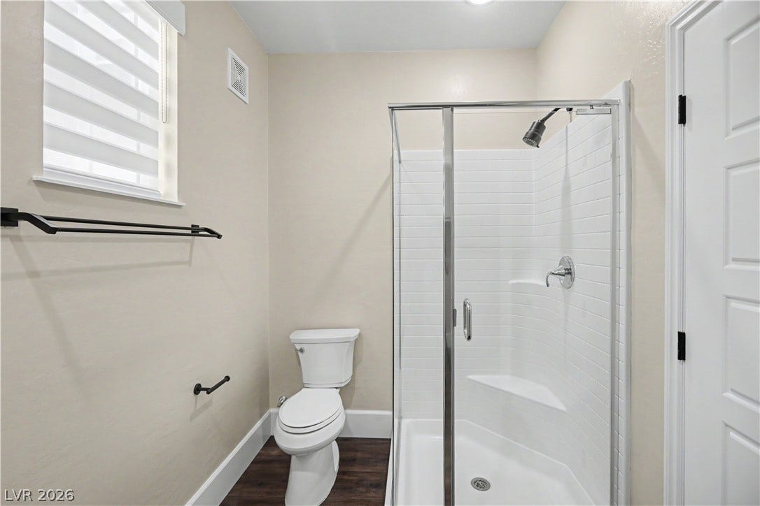 2555 Hampton Road, #11210, Henderson, NV 89052 The second en suite features a walk-in shower with a glass door, a window for natural light and black fixtures.