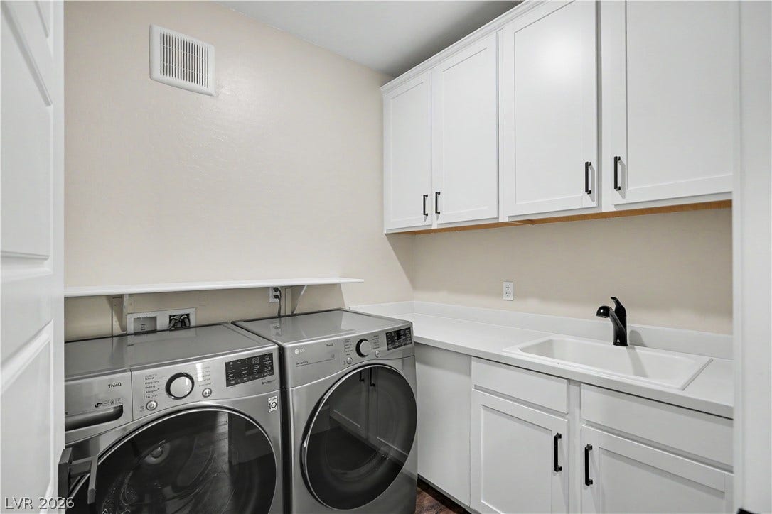 2555 Hampton Road, #11210, Henderson, NV 89052 Functional workspace highlights this practical laundry room featuring built-in cabinetry and a deep utility sink.