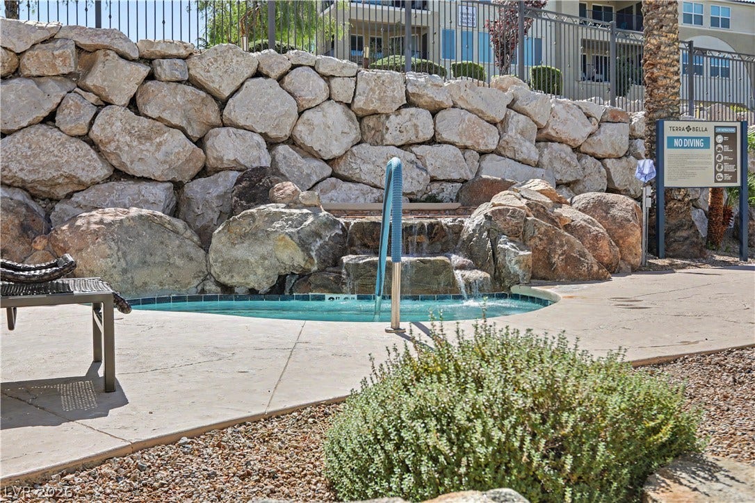 2555 Hampton Road, #11210, Henderson, NV 89052 Unwind in the community spa, set against a stunning natural rock wall with a cascading waterfall.
