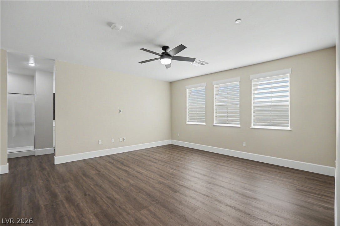 2555 Hampton Road, #11210, Henderson, NV 89052 Rich wood-inspired LVP flooring and ample natural light define this spacious primary bedroom.