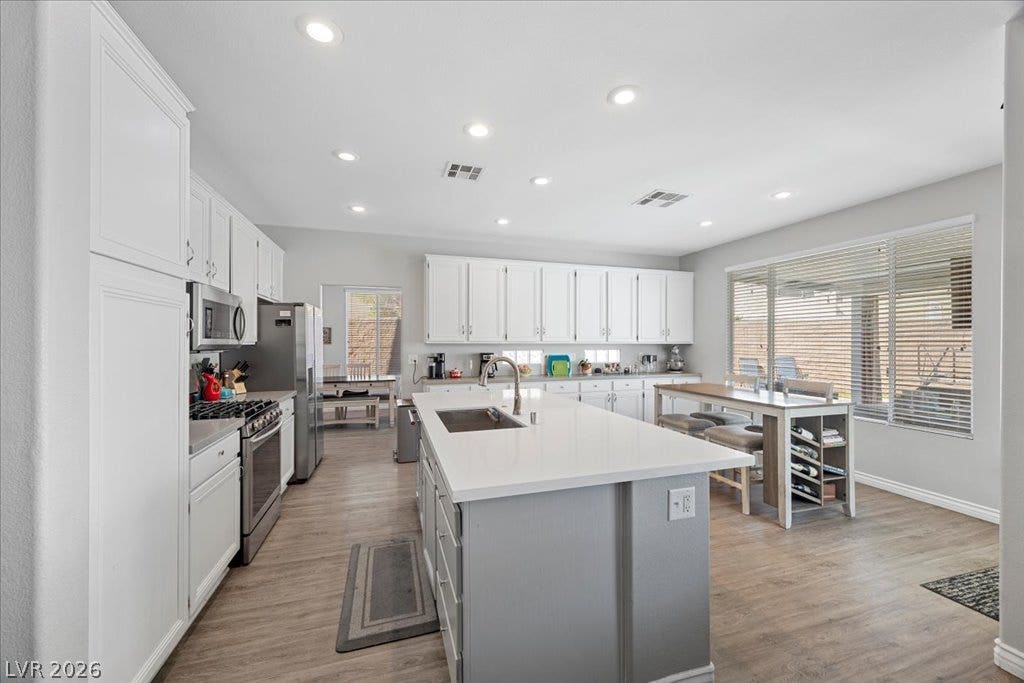2386 Flute Avenue, Henderson, NV 89052 Recessed lighting illuminates this modern kitchen featuring a large central island and wood flooring.