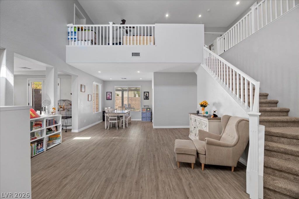 2386 Flute Avenue, Henderson, NV 89052 A spacious open-concept interior features wood-look floors, soaring ceilings, and a overlooking loft area.