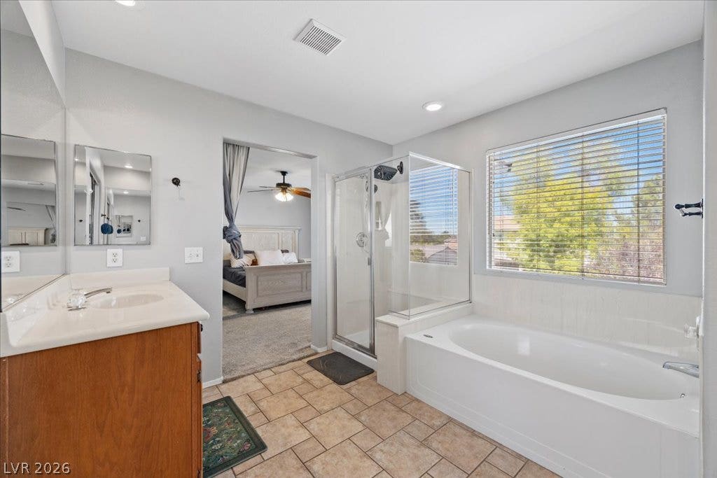 2386 Flute Avenue, Henderson, NV 89052 Tiled flooring and a separate soaking tub create a functional primary bathroom layout.
