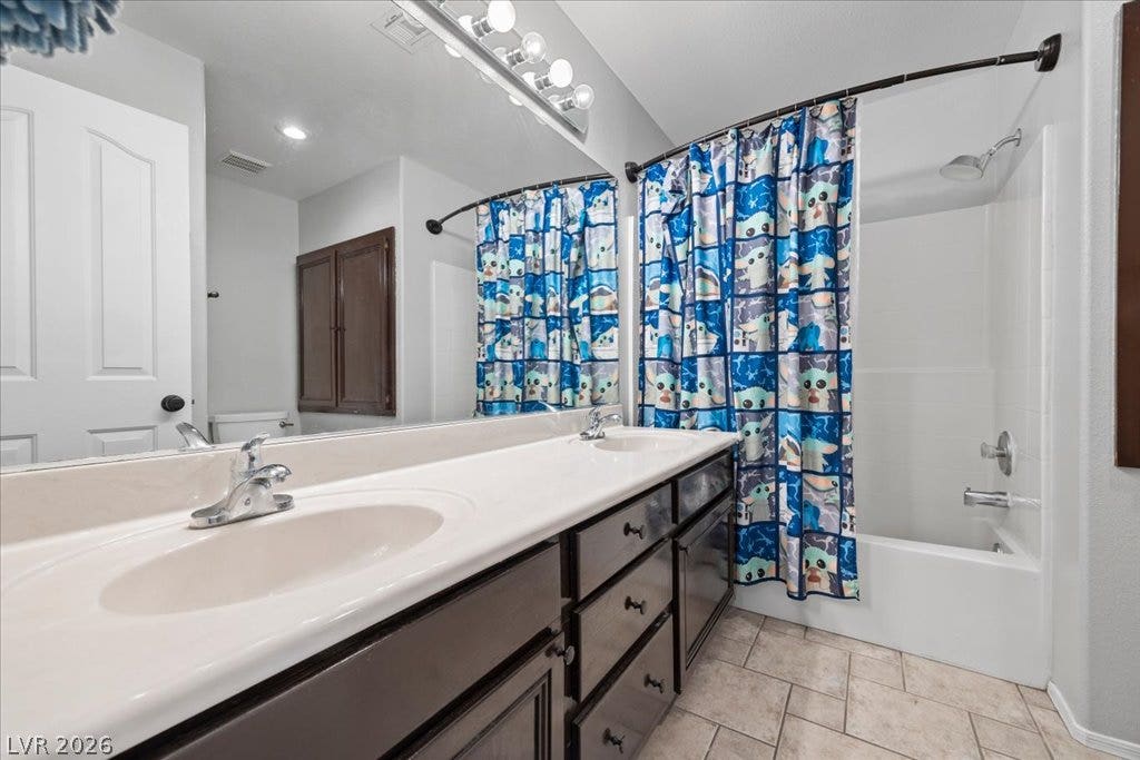2386 Flute Avenue, Henderson, NV 89052 A spacious double vanity and tile flooring highlight this functional bathroom design.
