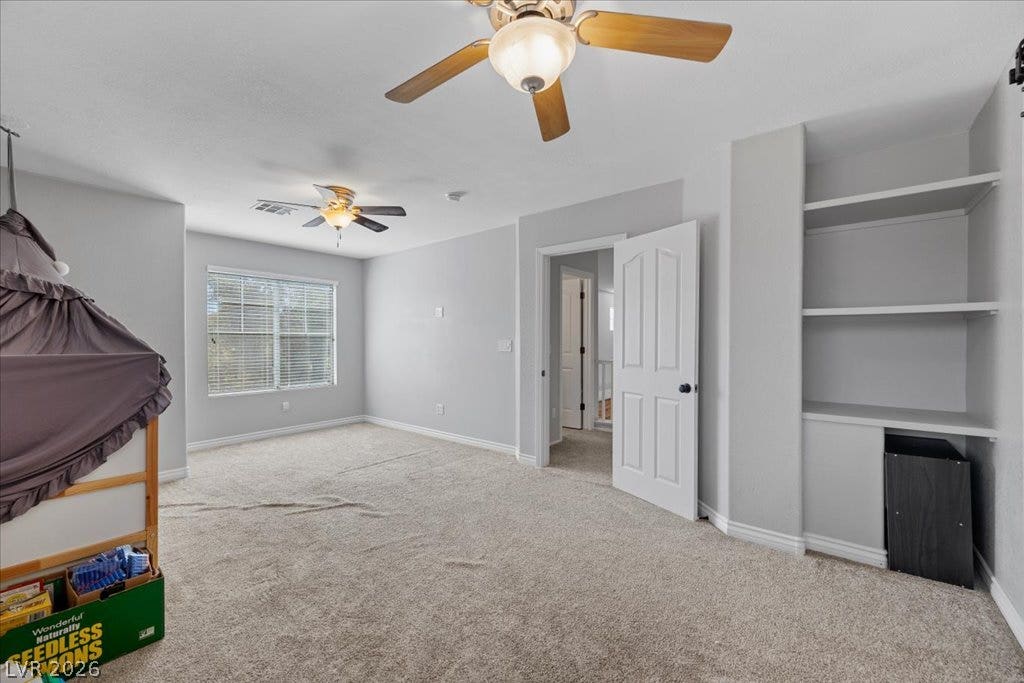 2386 Flute Avenue, Henderson, NV 89052 Plush carpeting underfoot and clean-lined built-in shelving define this versatile upstairs room.
