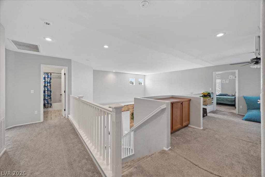 2386 Flute Avenue, Henderson, NV 89052 Plush carpeting and crisp white railings define this versatile upper-level landing space.