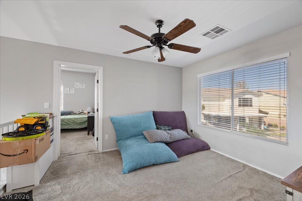 2386 Flute Avenue, Henderson, NV 89052 Soft carpeting pairs with a large window overlooking the neighborhood in this versatile space.