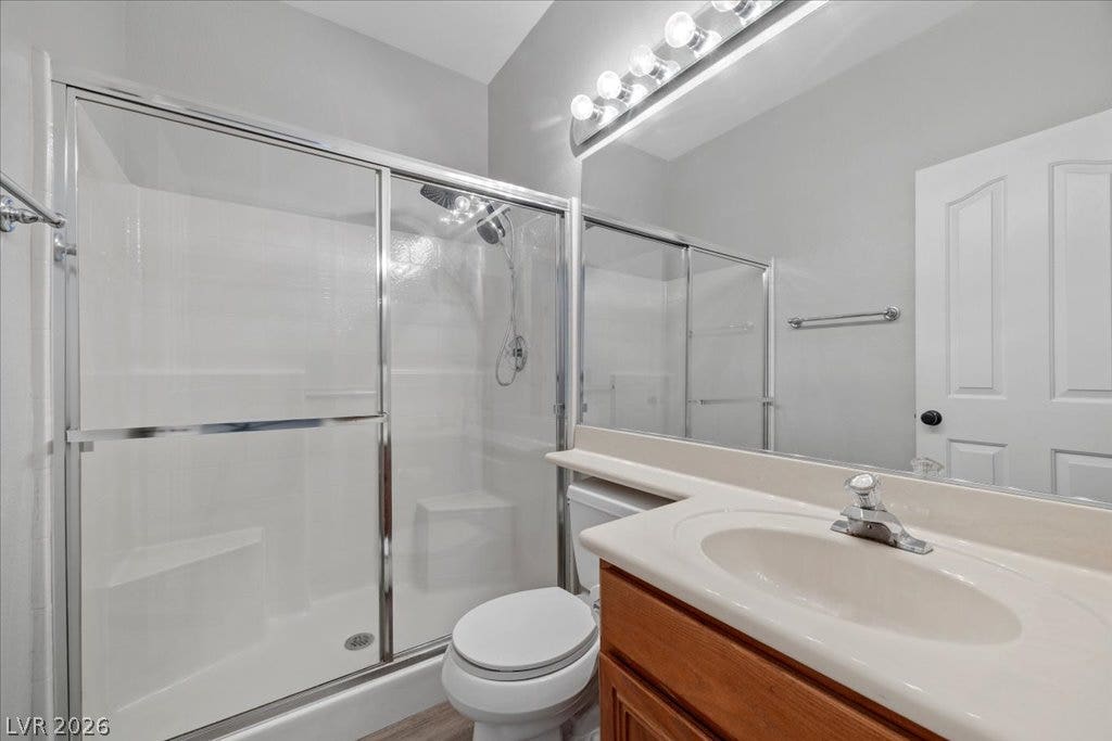 2386 Flute Avenue, Henderson, NV 89052 A classic vanity sits adjacent to a glass-enclosed walk-in shower in this bathroom.