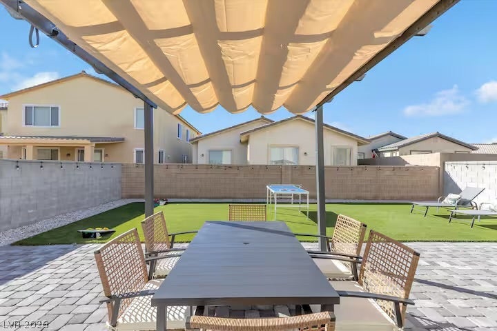 2713 Concord Street, North Las Vegas, NV 89030 An inviting paved patio sits beneath a modern retractable awning overlooking the neat green yard.