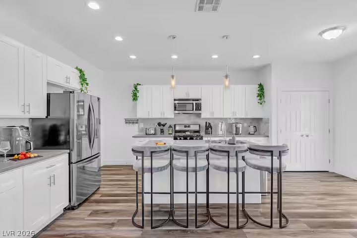 2713 Concord Street, North Las Vegas, NV 89030 An open kitchen layout showcases sleek cabinetry and a central island over wood-style flooring.