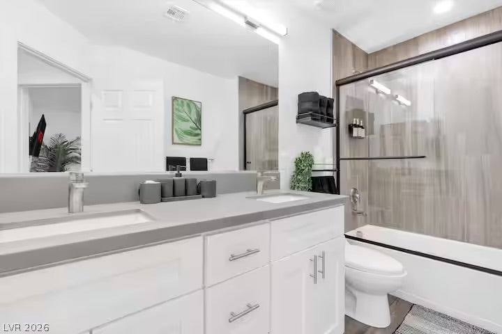 2713 Concord Street, North Las Vegas, NV 89030 A contemporary bathroom features a double vanity with grey stone counters and recessed lighting.