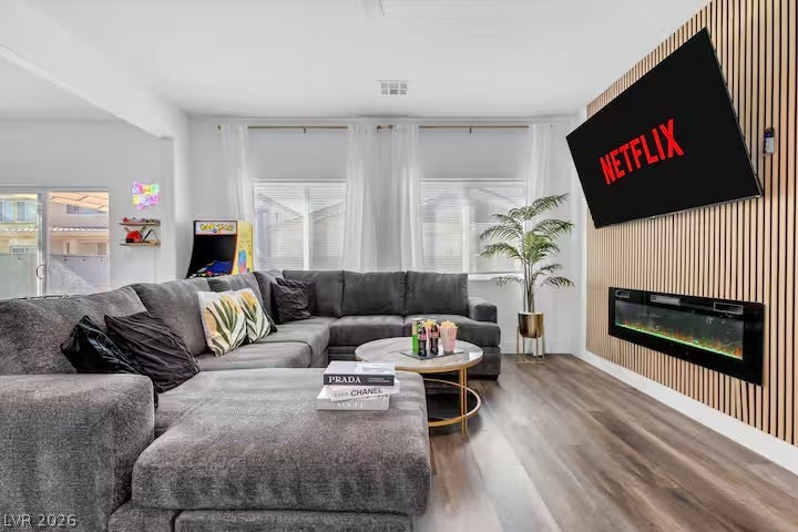 2713 Concord Street, North Las Vegas, NV 89030 Rich wood-look flooring and a modern slatted accent wall elevate this inviting living space.
