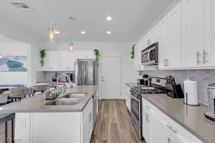 2713 Concord Street, North Las Vegas, NV 89030 Gleaming stone countertops and matching cabinetry surround a spacious kitchen island with recessed lighting.