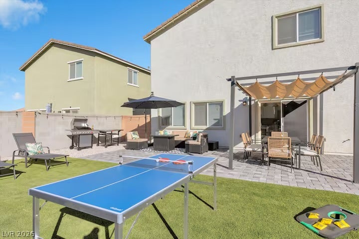 2713 Concord Street, North Las Vegas, NV 89030 An inviting backyard patio features stone pavers, synthetic turf, and a shaded pergola structure.
