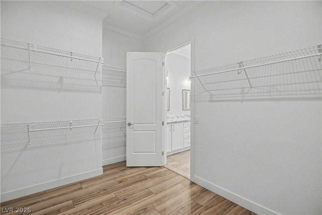 2073 Fountain City Street, Henderson, NV 89052 The spacious primary walk-in closet offers double-tier hanging rods and shelving that wraps around the room.