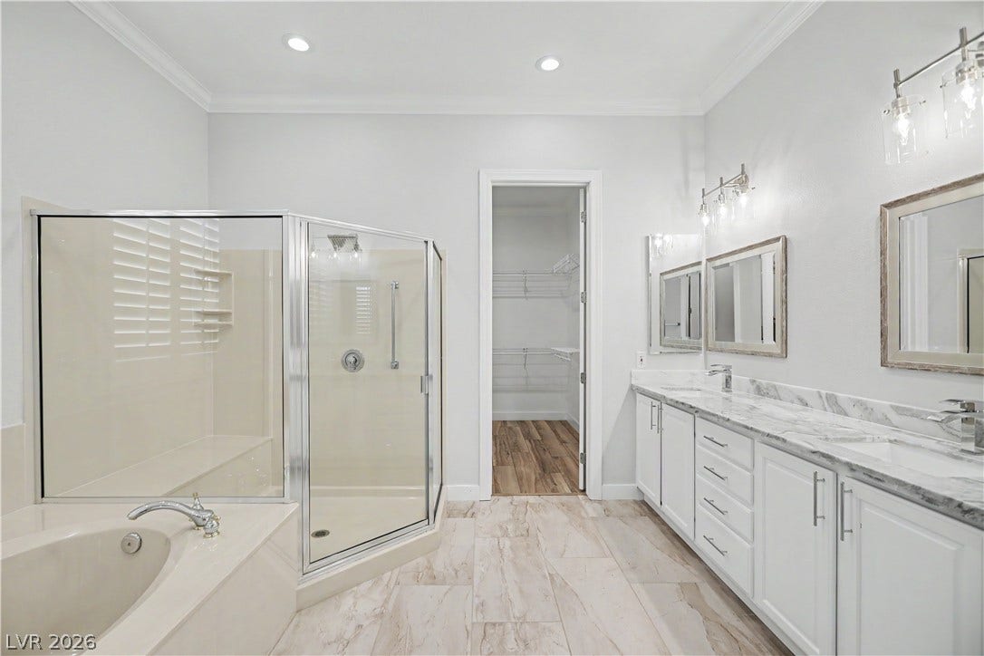 2073 Fountain City Street, Henderson, NV 89052 A long dual vanity with marble countertop, two mirrors, and modern glass light fixtures means plenty of room to get ready side by side.