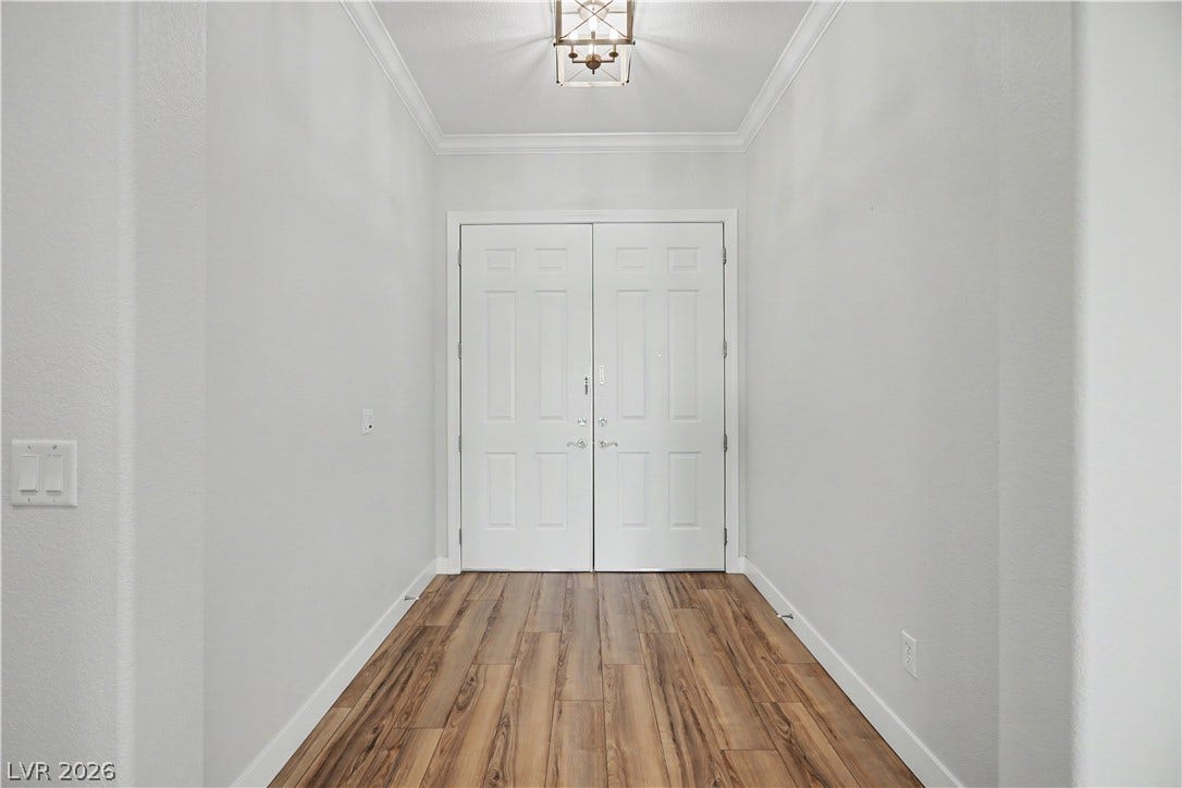 2073 Fountain City Street, Henderson, NV 89052 The light-filled foyer sets the tone with neutral paint, crown molding and wood-look laminate flooring and a charming pendant light.