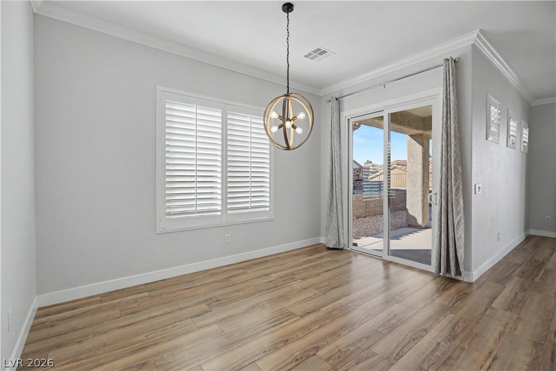 2073 Fountain City Street, Henderson, NV 89052 The bright breakfast nook features plantation shutters, a modern orb chandelier, and a sliding glass door to the covered patio.