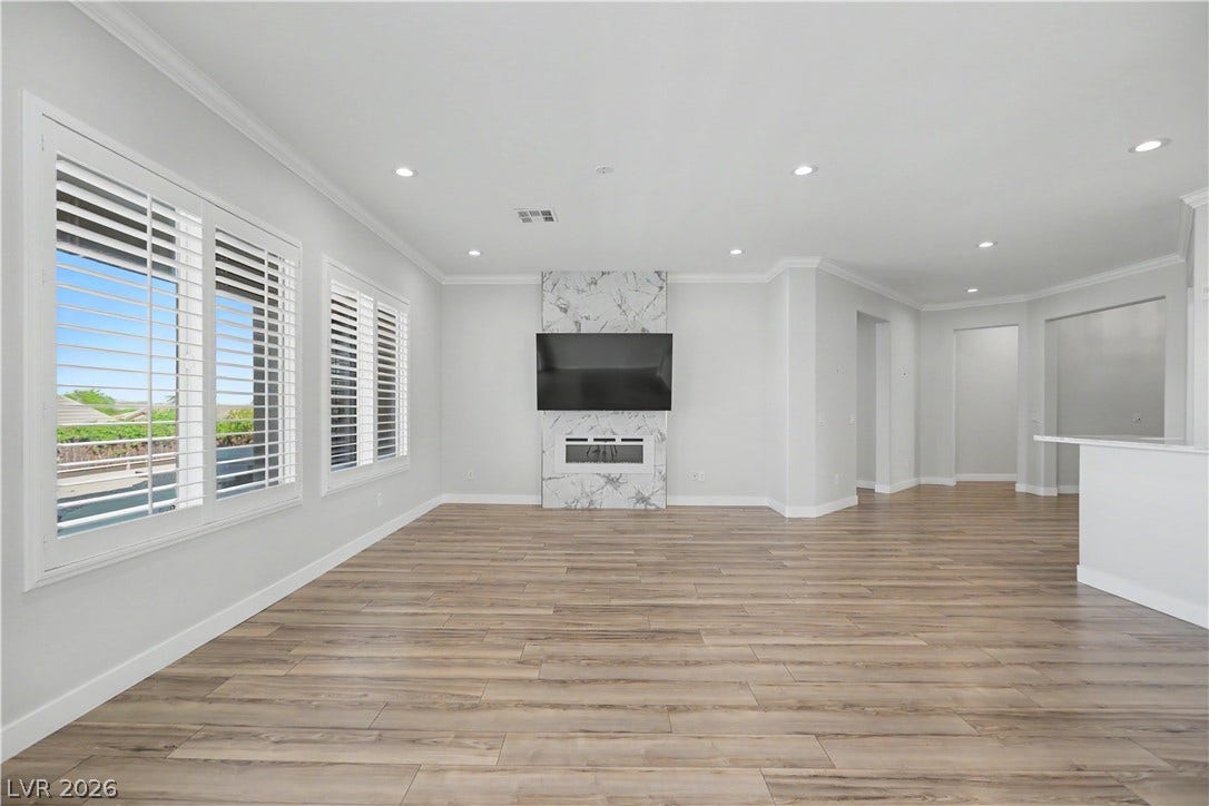 2073 Fountain City Street, Henderson, NV 89052 Wall-to wall windows with plantation shutters frame backyard views and fill the living room with natural light.