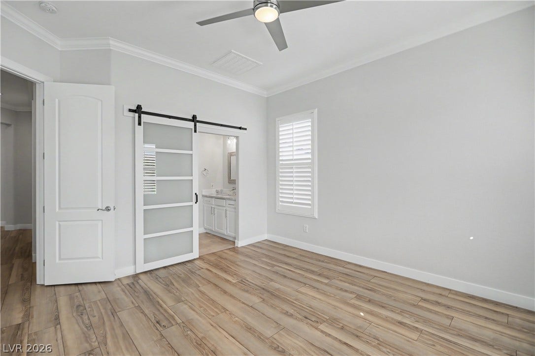 2073 Fountain City Street, Henderson, NV 89052 The second bedroom features a modern sliding barn door with frosted glass panels that opens to a private en suite bath.