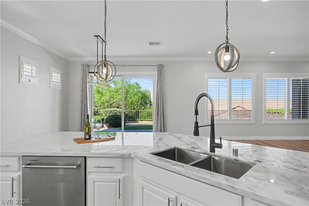 2073 Fountain City Street, Henderson, NV 89052 The island sink overlooks the dining area and lush greenery through the patio slider.
